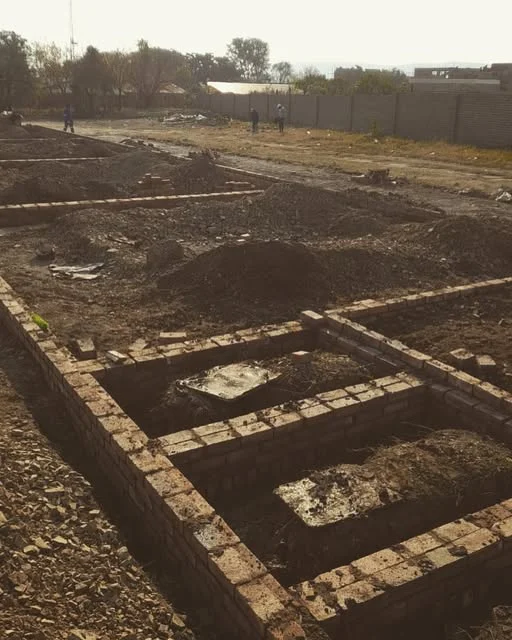 Brick foundation walls set out across a cleared site